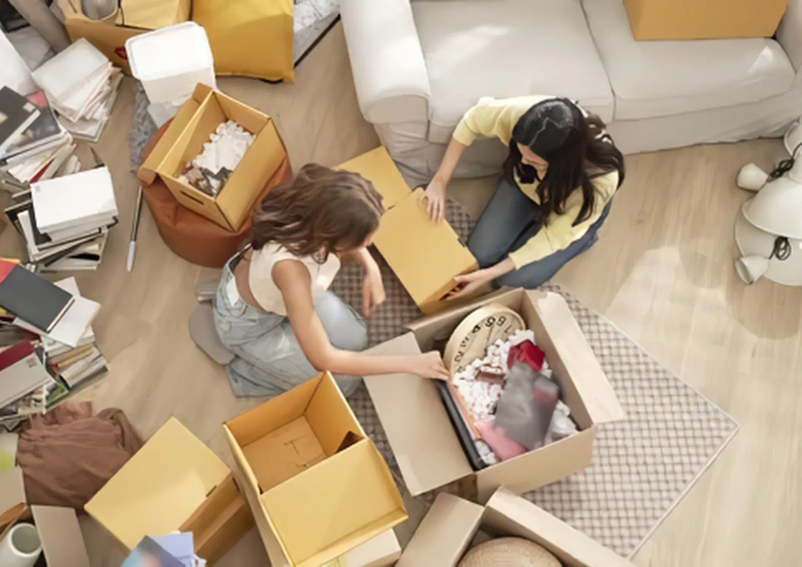 Zwei Frauen packen Umzugskartons